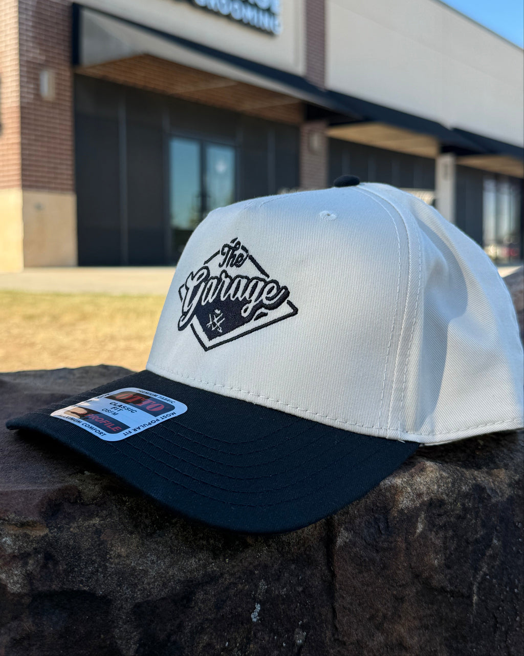 White hat of "The Garage" with black brim